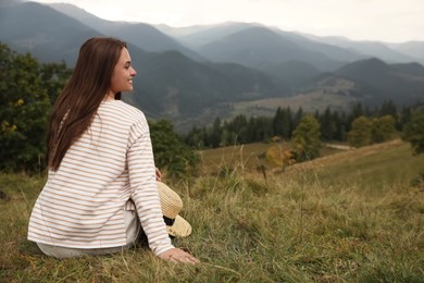 Photo of Young woman enjoying beautiful mountain landscape. Space for text