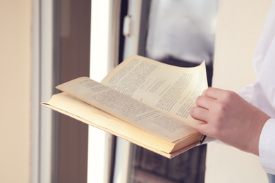 Woman reading old book outdoors, closeup view