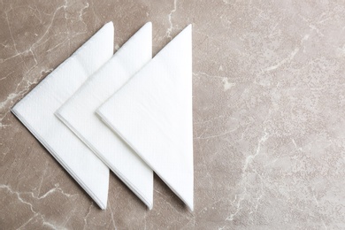 Photo of Clean napkins on marble table, flat lay. Space for text