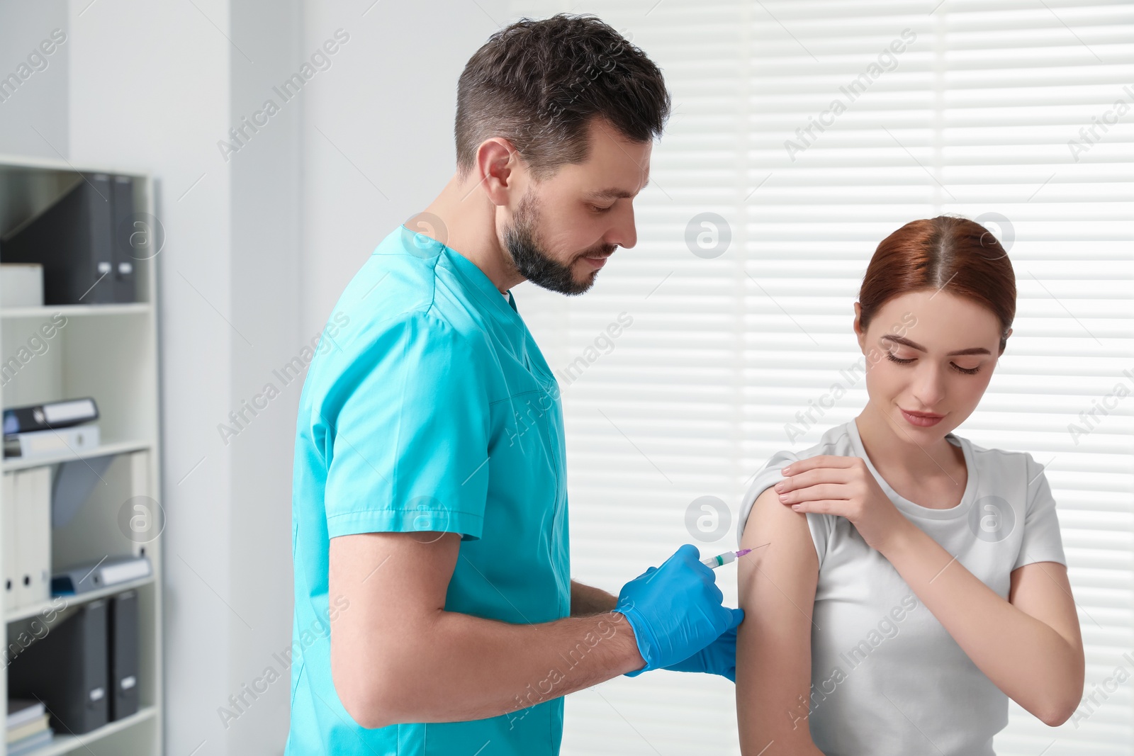 Photo of Doctor giving hepatitis vaccine to patient in clinic