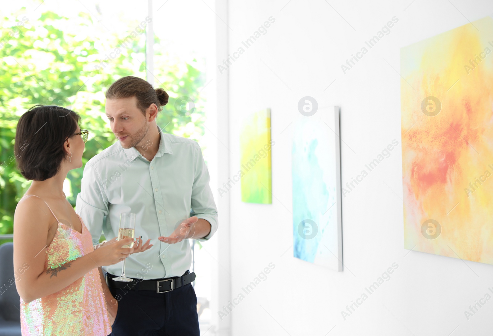 Photo of Young couple at exhibition in art gallery