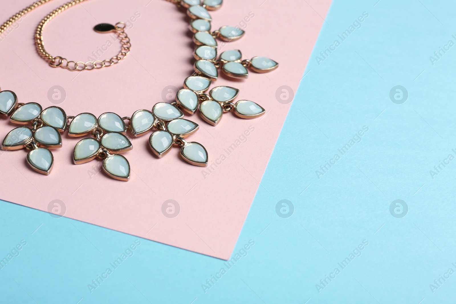 Photo of Elegant necklace on color background, space for text. Luxury jewelry