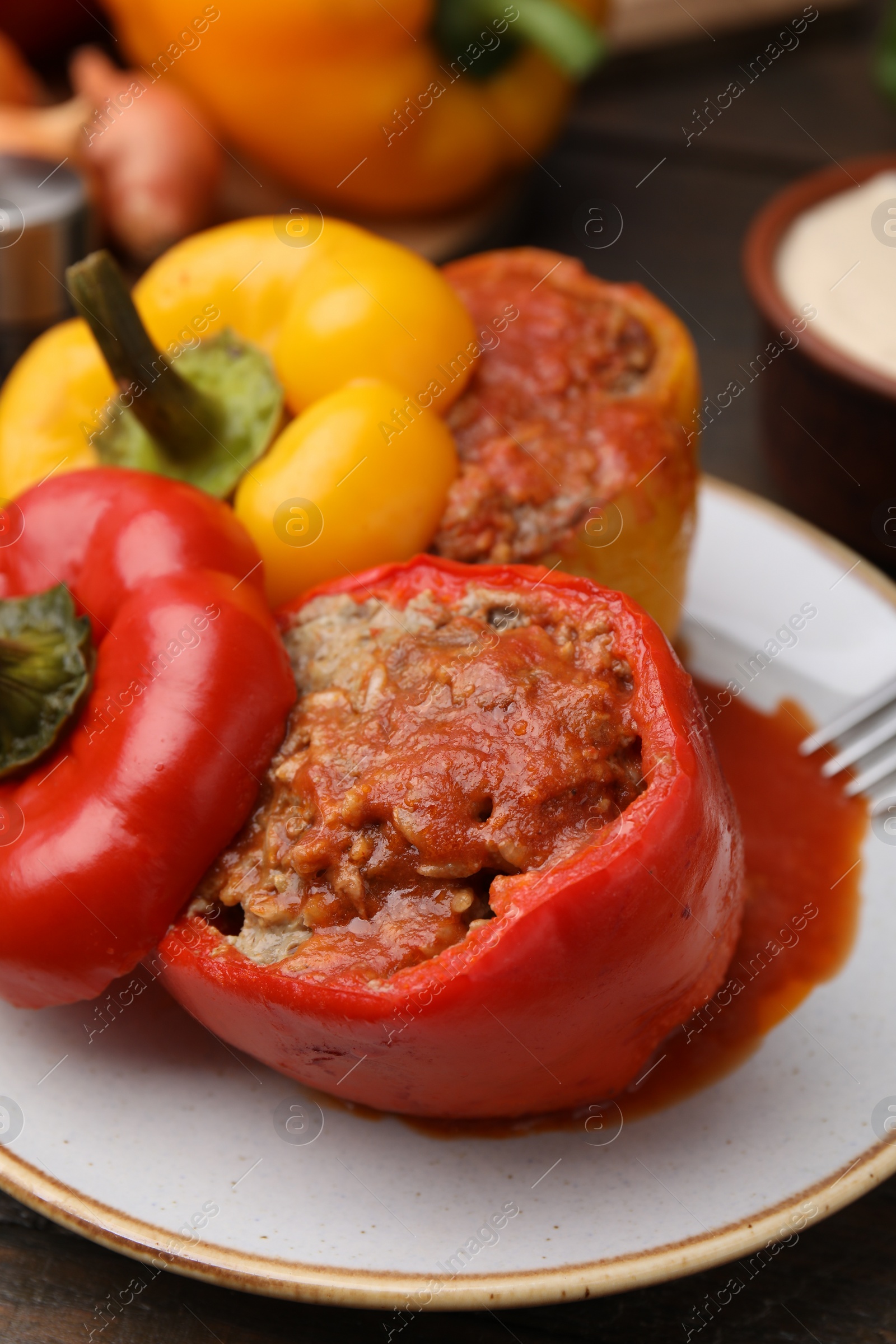 Photo of Delicious stuffed bell peppers served on wooden table, closeup