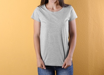 Photo of Young woman in grey t-shirt on color background. Mockup for design