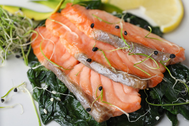 Photo of Tasty freshly cooked salmon with spinach, closeup