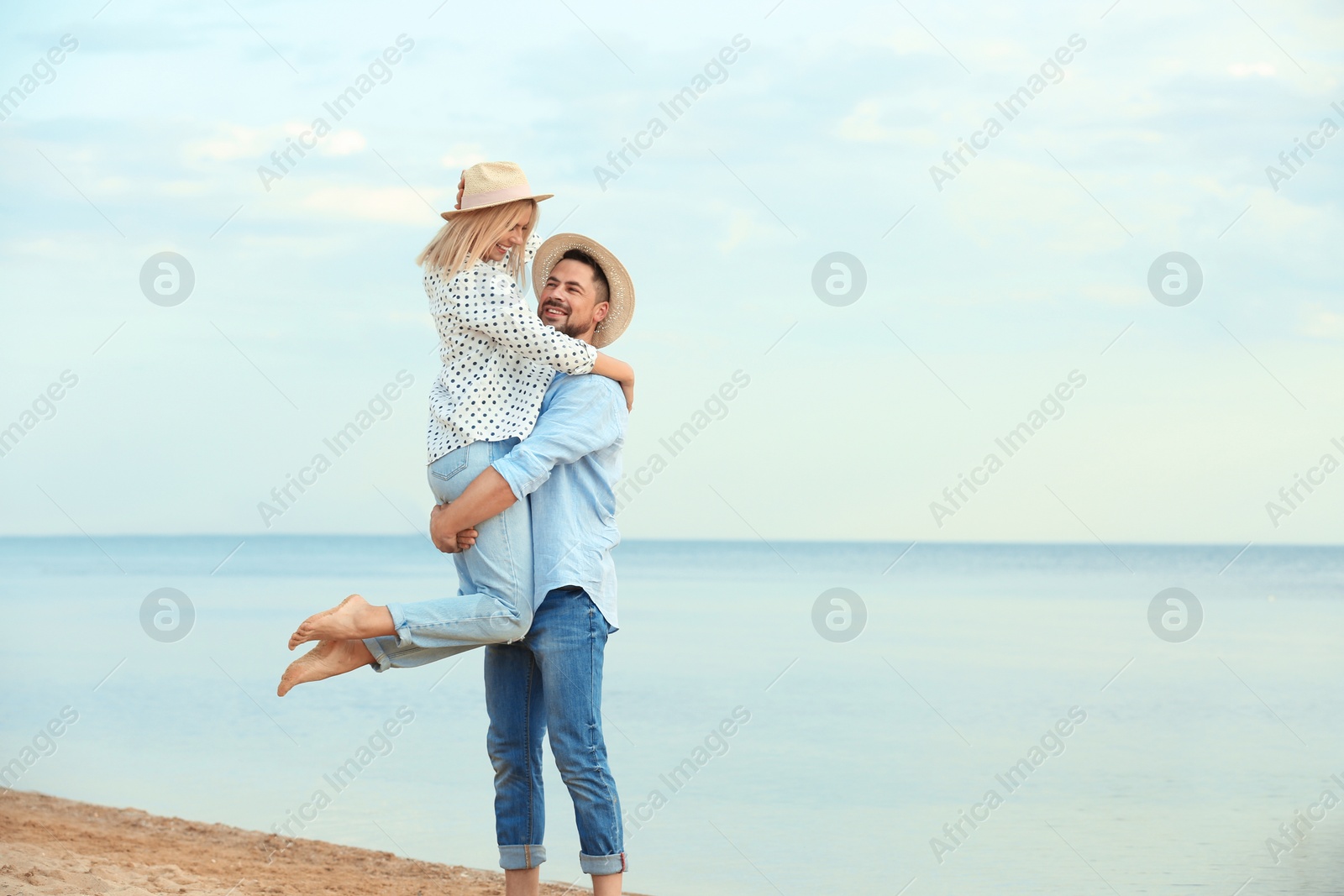 Photo of Happy romantic couple spending time together on beach, space for text