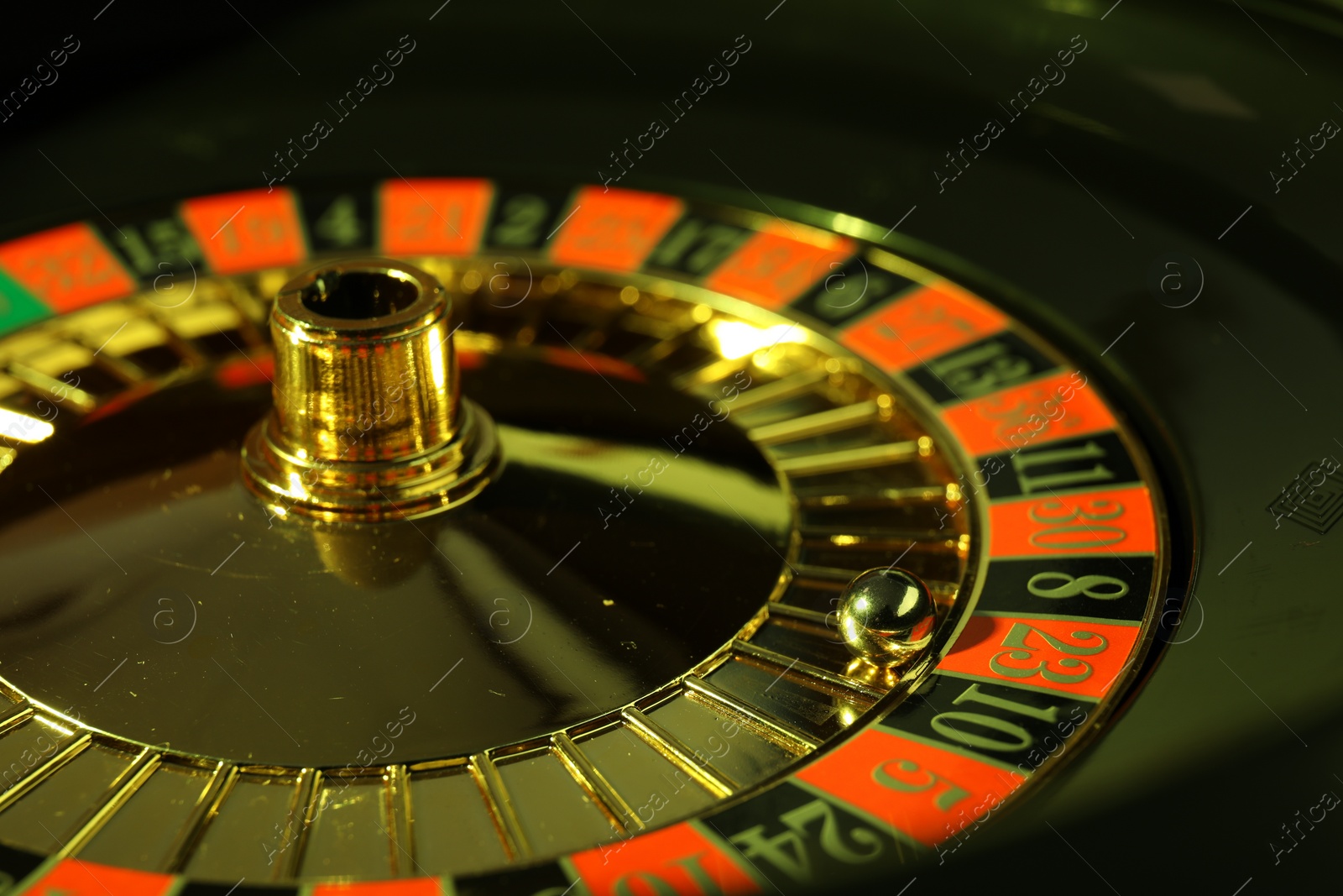 Photo of Roulette wheel with ball, closeup. Casino game