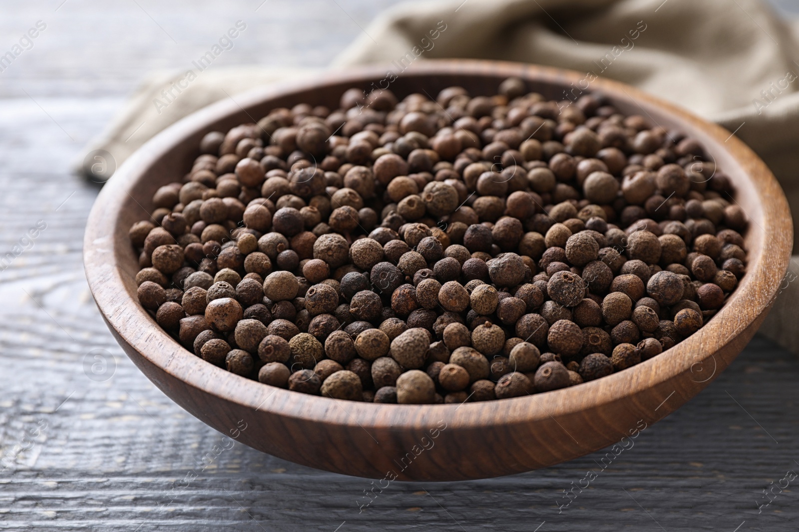 Photo of Peppercorns on light grey wooden table, closeup