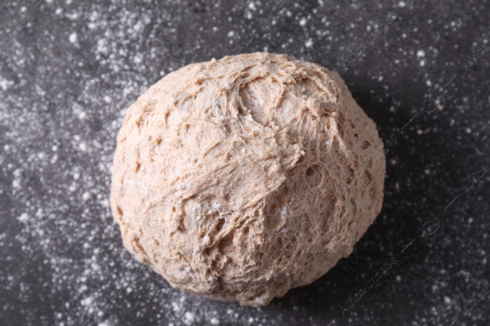 Photo of Fresh sourdough and flour on grey table, top view