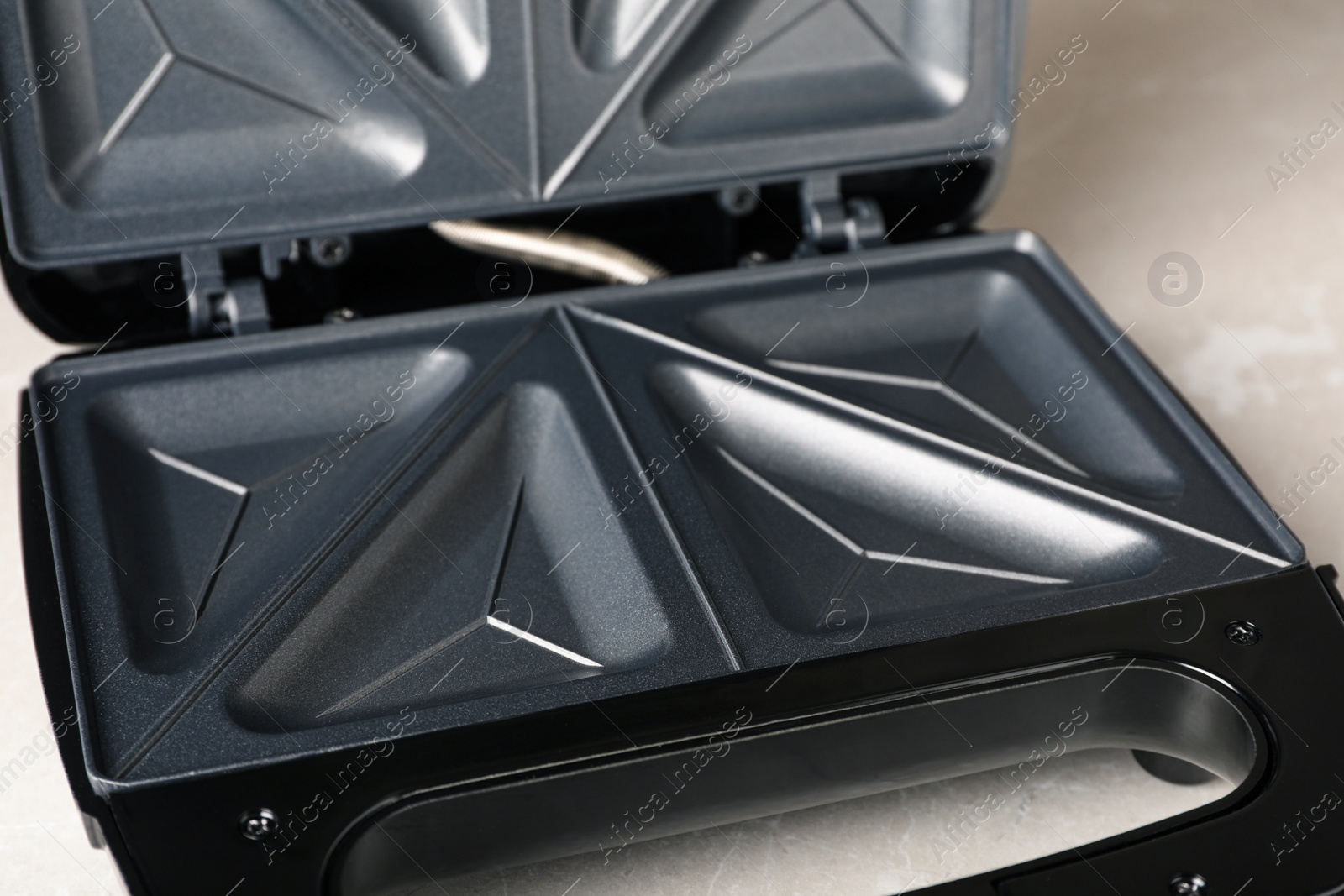 Photo of Open modern sandwich maker on white table, closeup