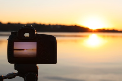 Photo of  beautiful riverside sunset on display of professional camera, closeup