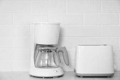 Photo of Modern toaster and coffeemaker on countertop in kitchen