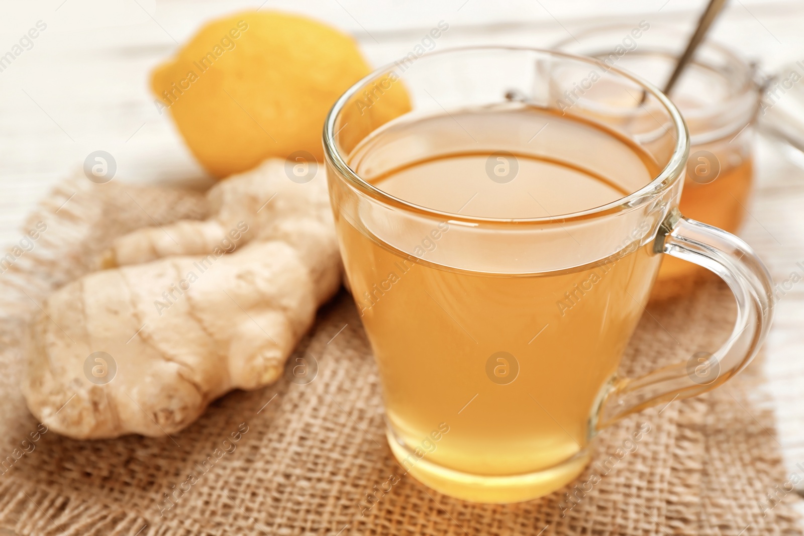 Photo of Cup with hot tea and ginger for cold on table