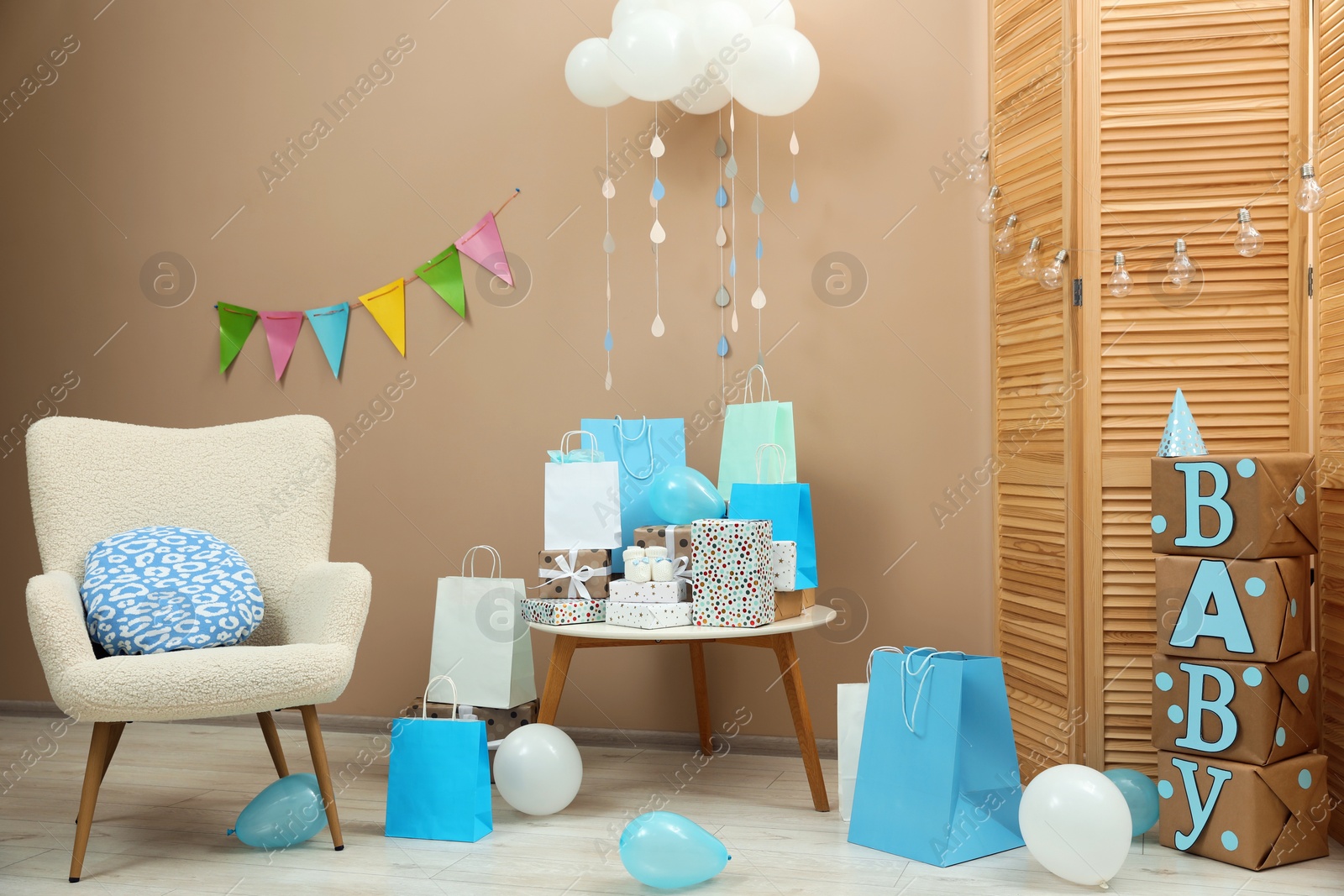 Photo of Baby shower party. Festive decor, gift boxes and bags in stylish room