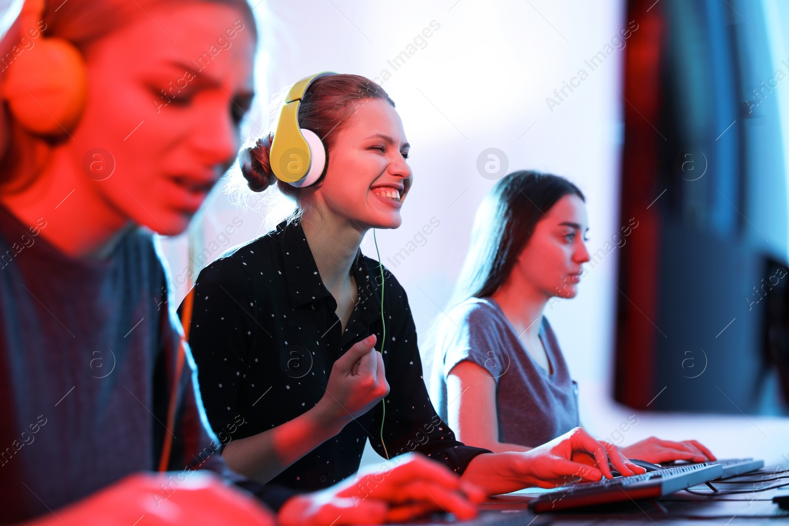 Photo of Young people playing video games on computers indoors. Esports tournament