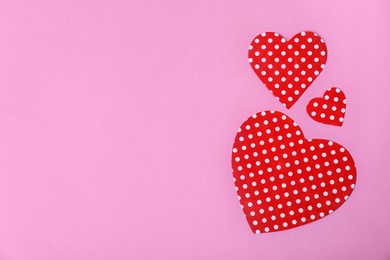 Paper hearts and space for text on color background, top view