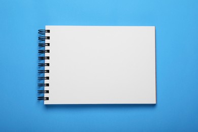 Open notebook on light blue background, top view