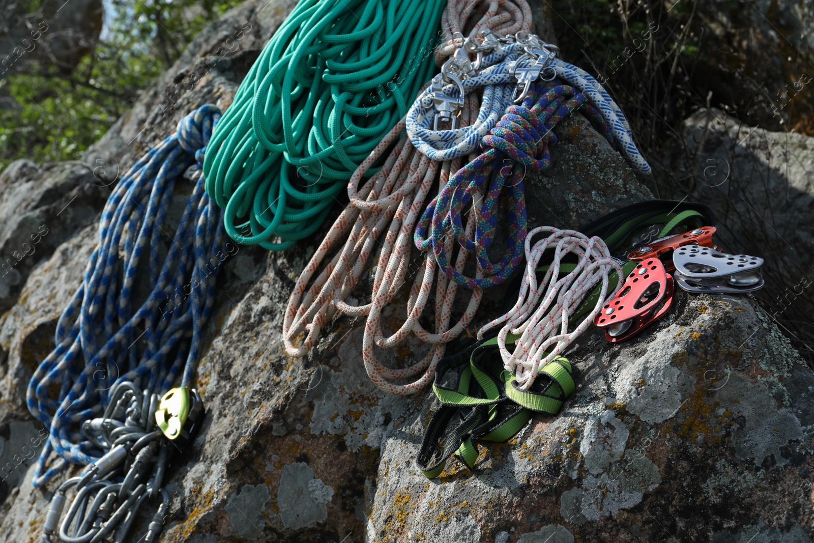 Photo of Different ropes and other climbing equipment on rocks outdoors