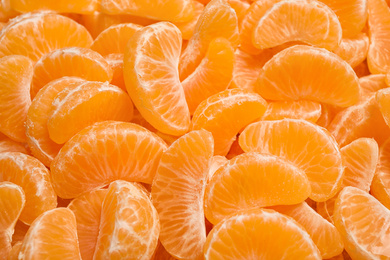 Photo of Fresh juicy tangerine segments as background, closeup