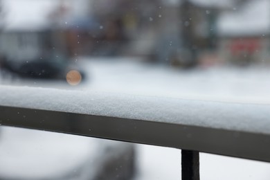 Handrail covered with snow outdoors, closeup view