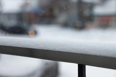 Photo of Handrail covered with snow outdoors, closeup view