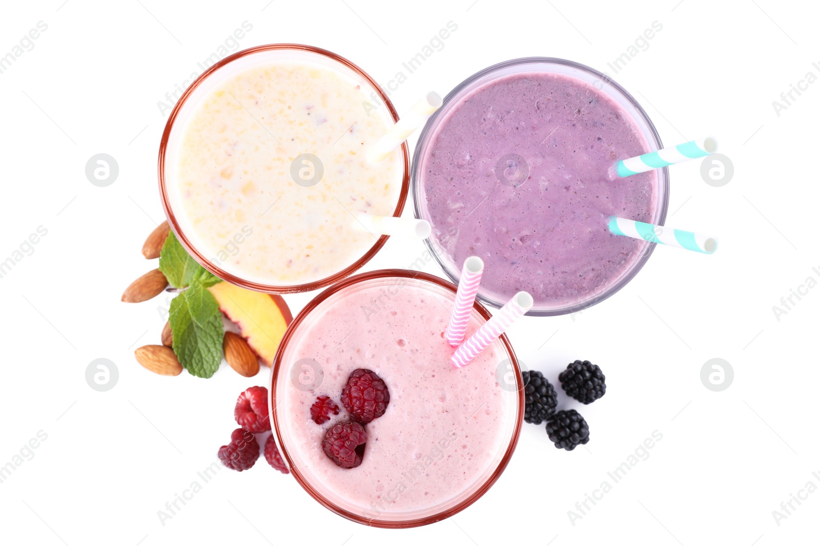 Photo of Different fresh tasty milk shakes in glasses with ingredients on white background, top view