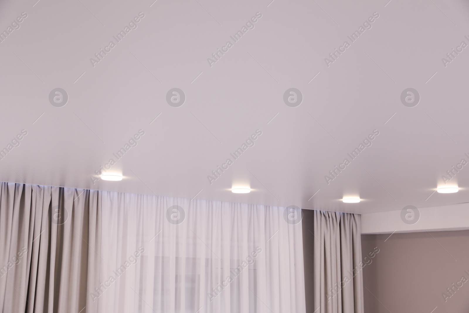 Photo of White ceiling with lamps indoors, below view