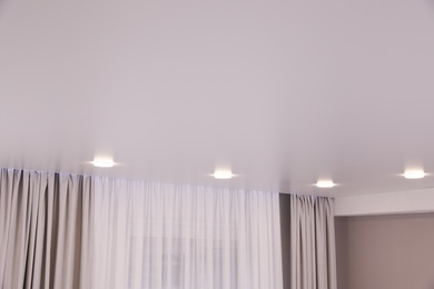 Photo of White ceiling with lamps indoors, below view