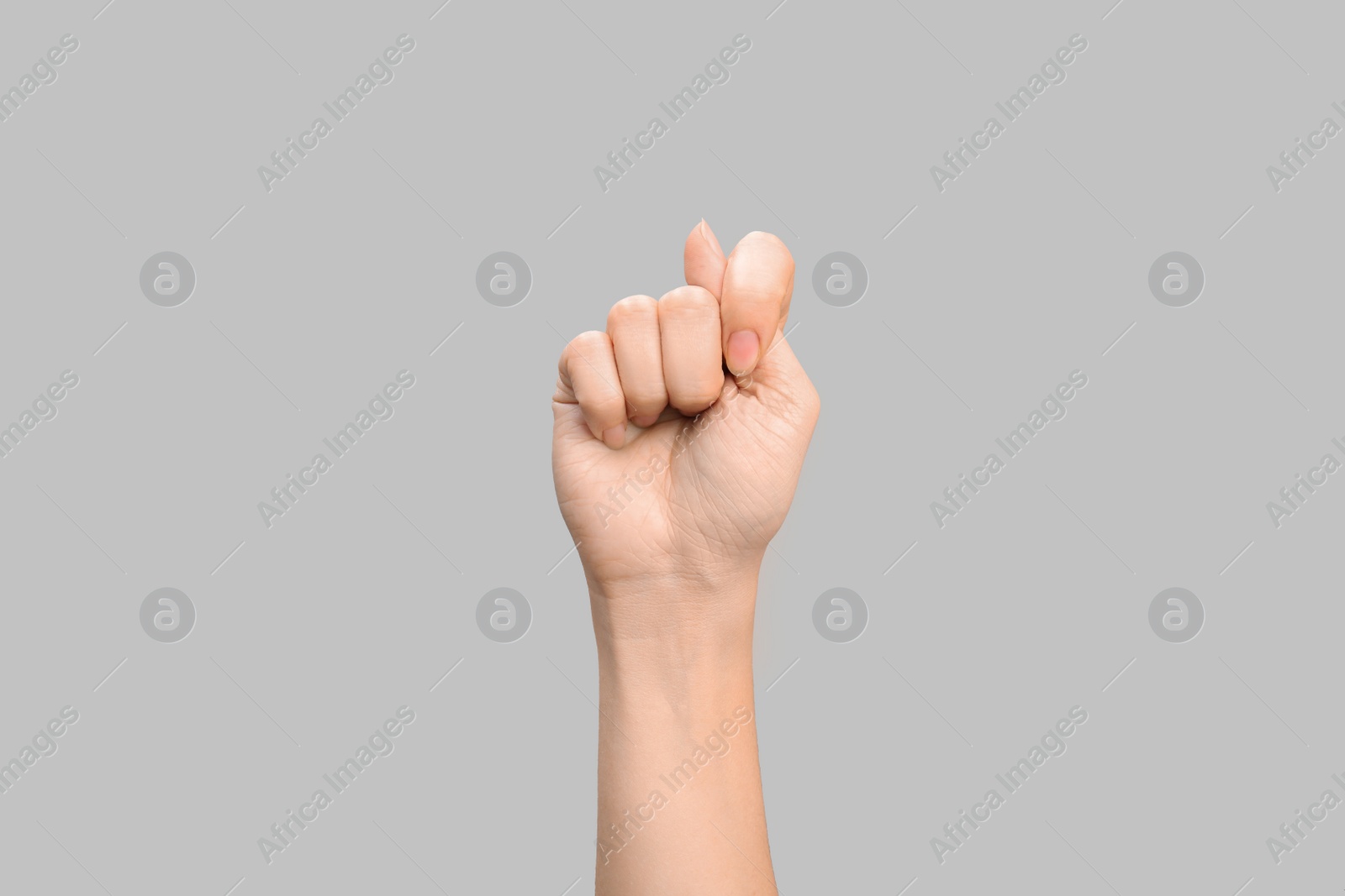 Photo of Woman showing T letter on grey background, closeup. Sign language
