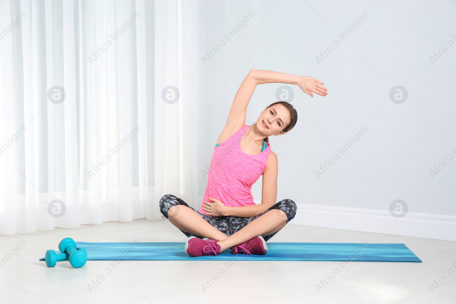 Photo of Young woman doing fitness exercises at home