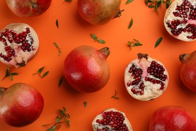 Photo of Flat lay composition with ripe pomegranates on orange background