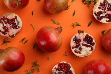 Flat lay composition with ripe pomegranates on orange background