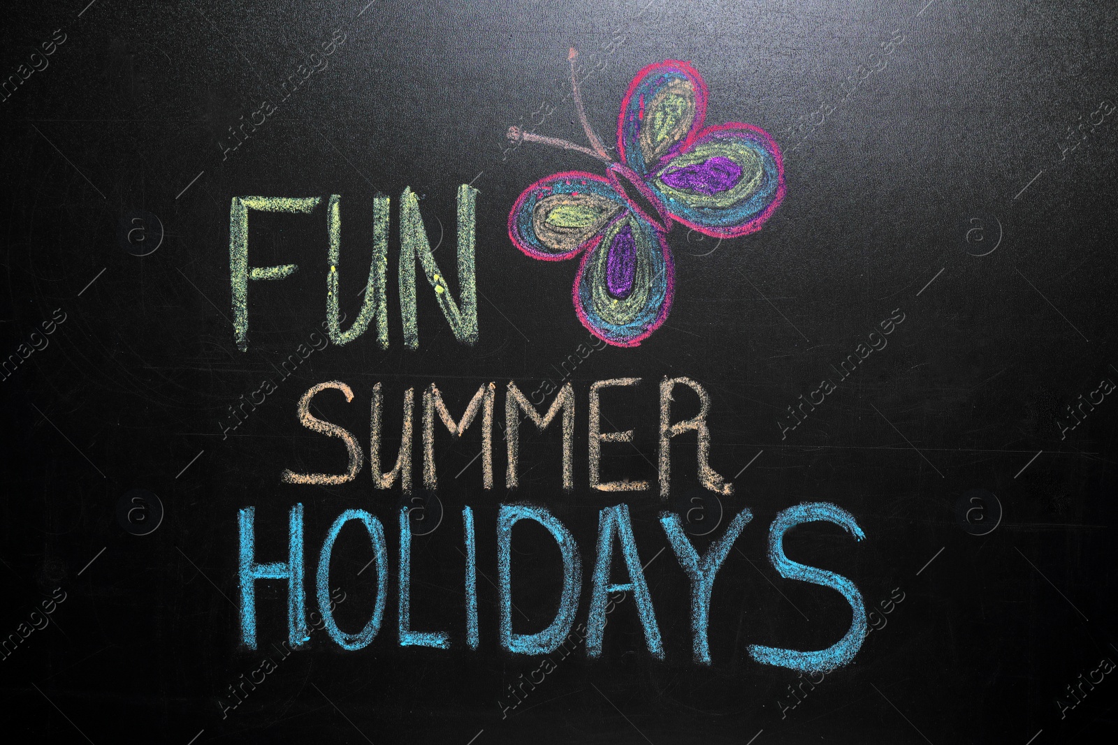 Photo of Inscription Fun Summer Holidays and drawing of butterfly on blackboard. School break