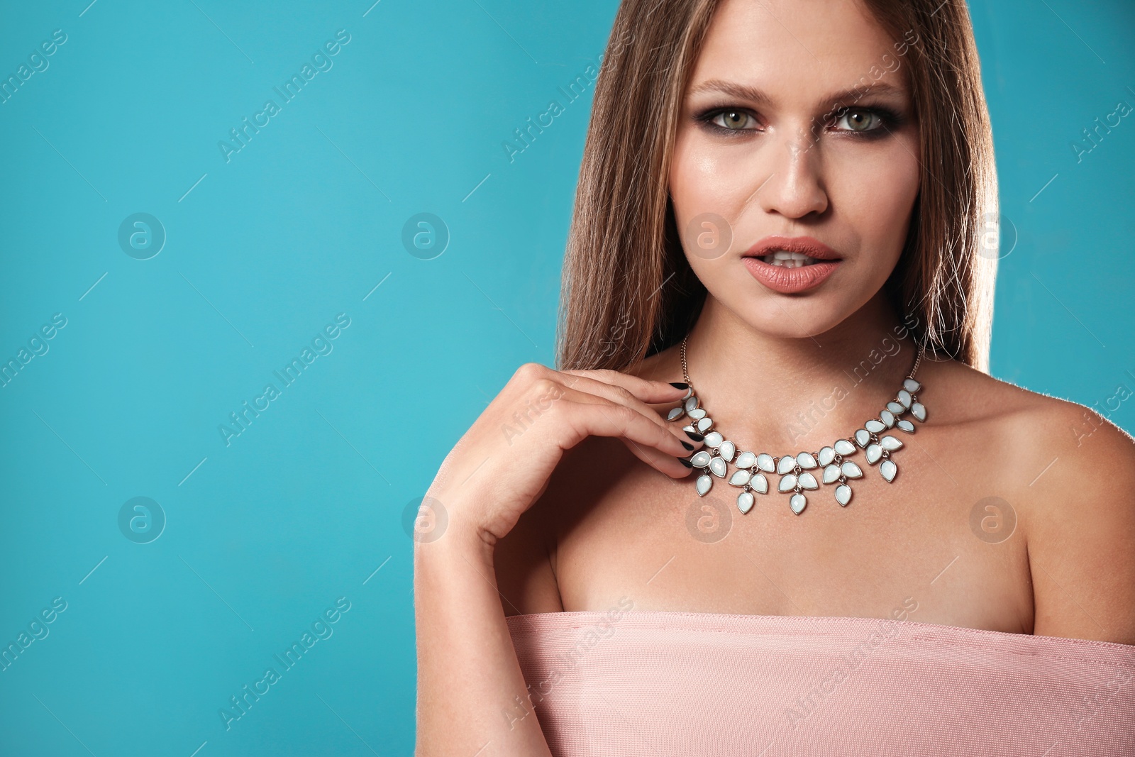 Photo of Beautiful woman with stylish jewelry on color background, space for text