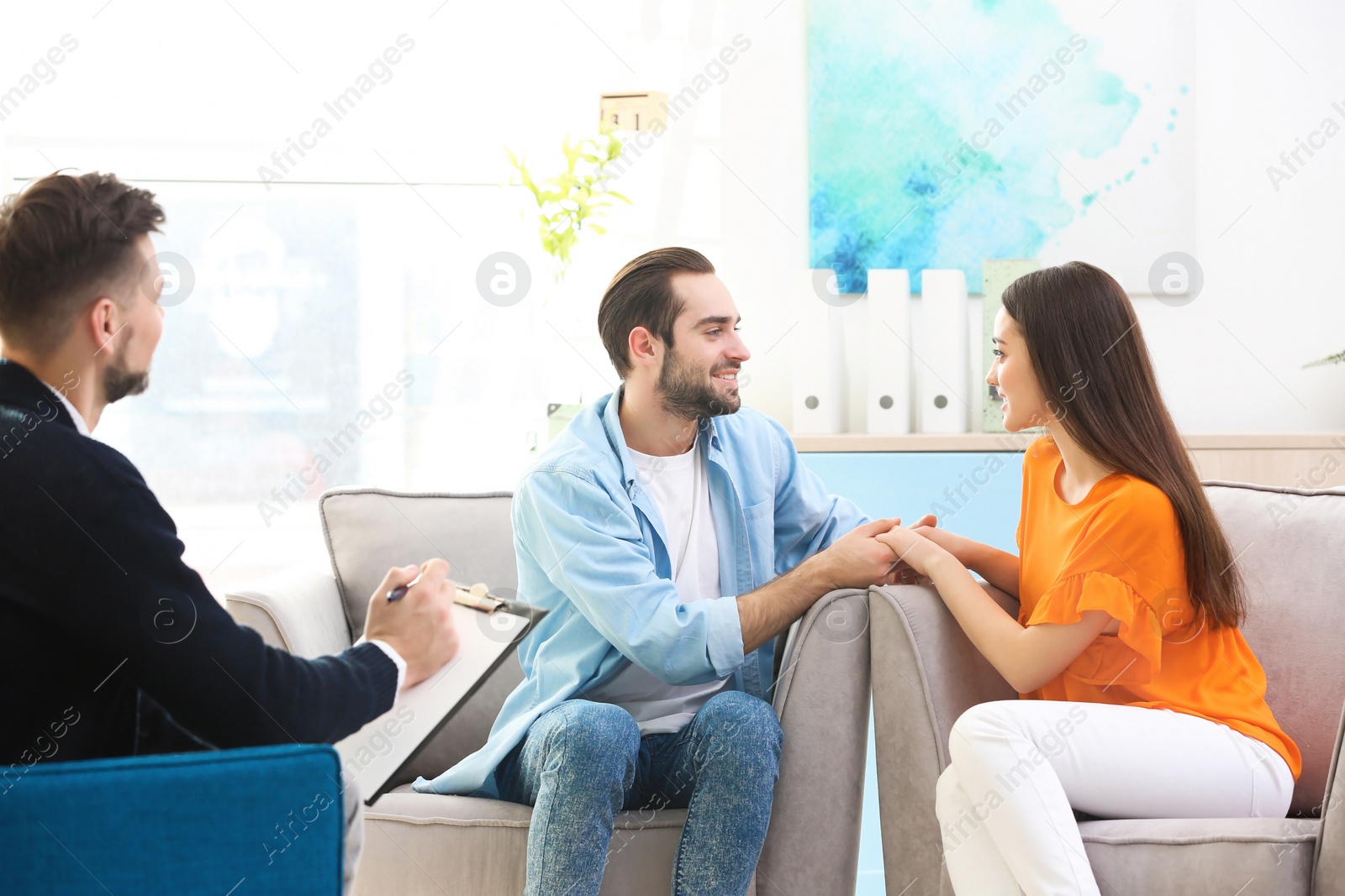 Photo of Family psychologist working with young couple in office