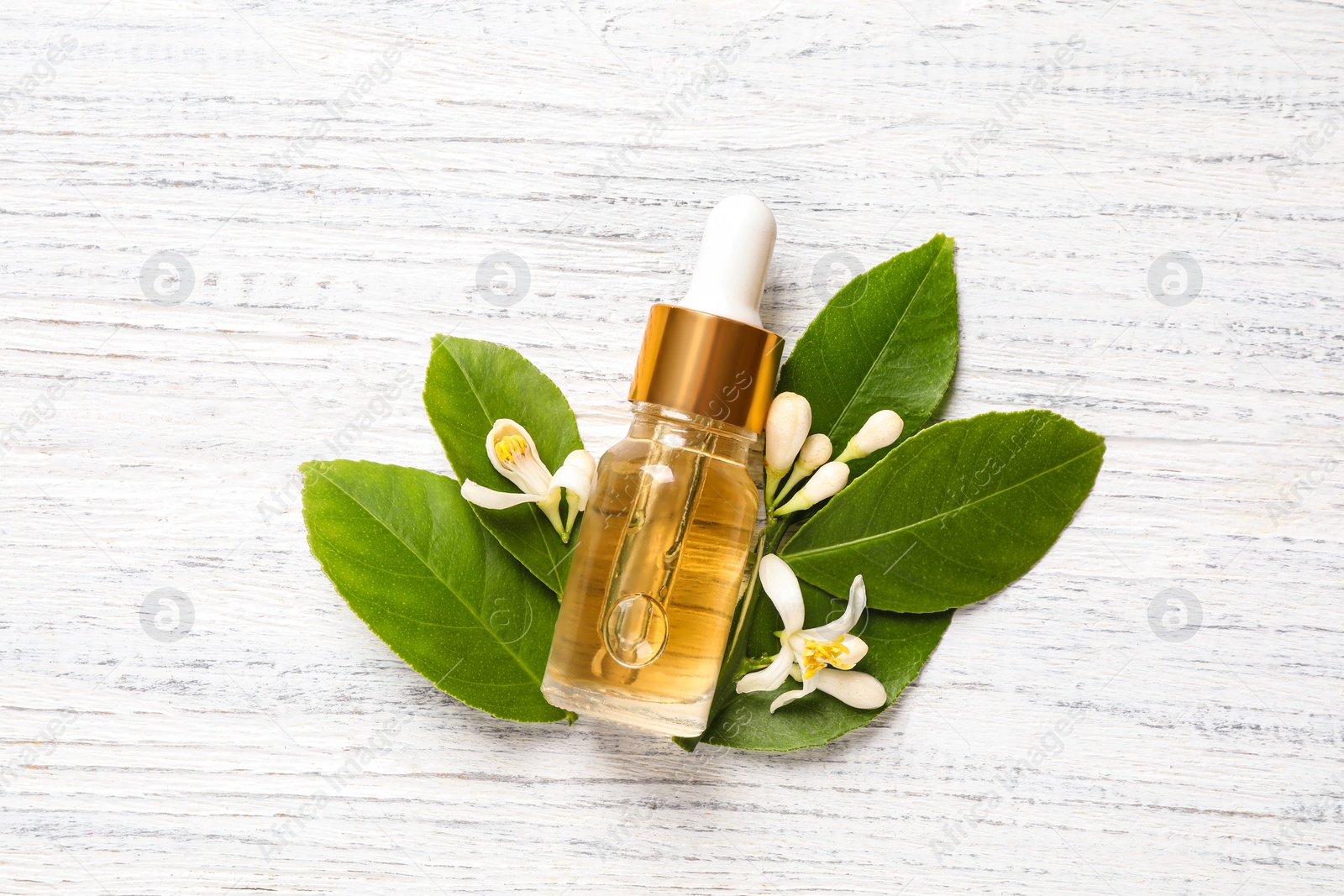 Photo of Flat lay composition with bottle of citrus essential oil on white wooden background