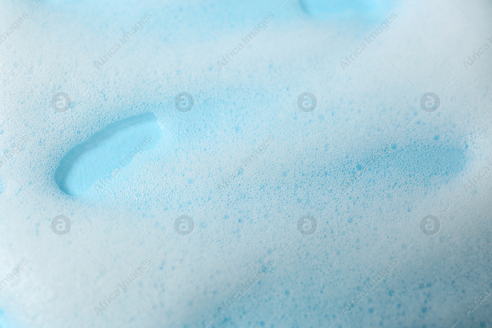 Photo of Foam on light blue background, top view. Face cleanser, skin care cosmetic