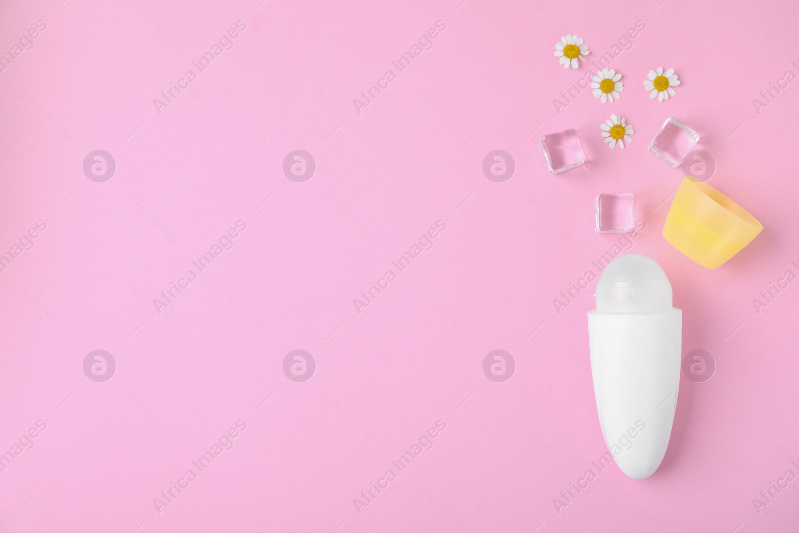 Photo of Flat lay composition with natural female roll-on deodorant on pink background, space for text