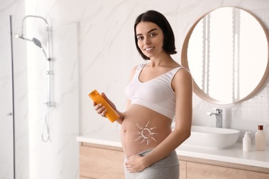 Photo of Young pregnant woman with sun protection cream in bathroom