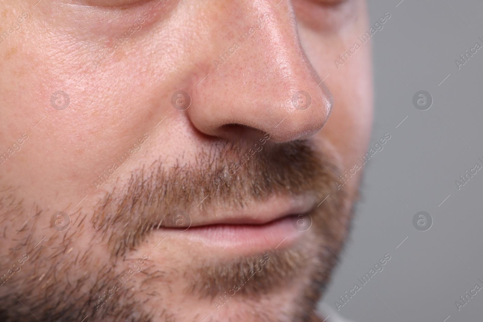 Photo of Closeup view of man with normal skin on grey background, space for text