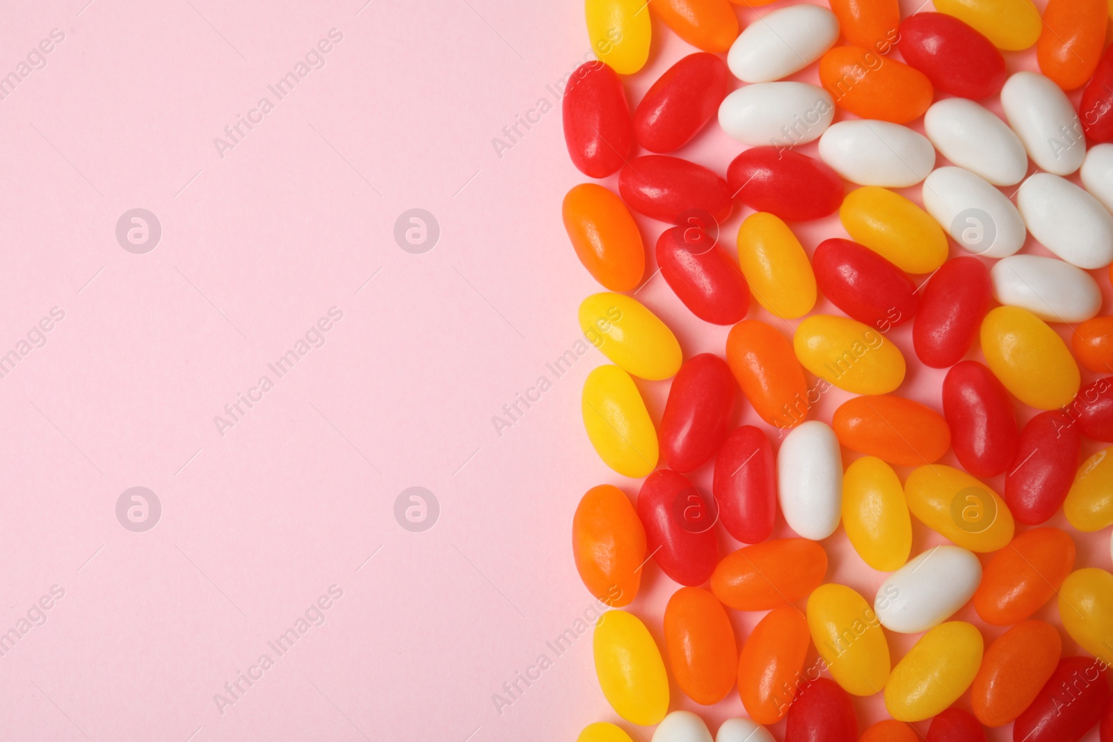 Photo of Flat lay composition with jelly beans on color background. Space for text