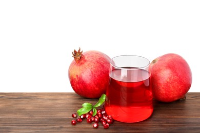 Photo of Refreshing pomegranate juice in glass, leaves and fruits on wooden table against white background. Space for text