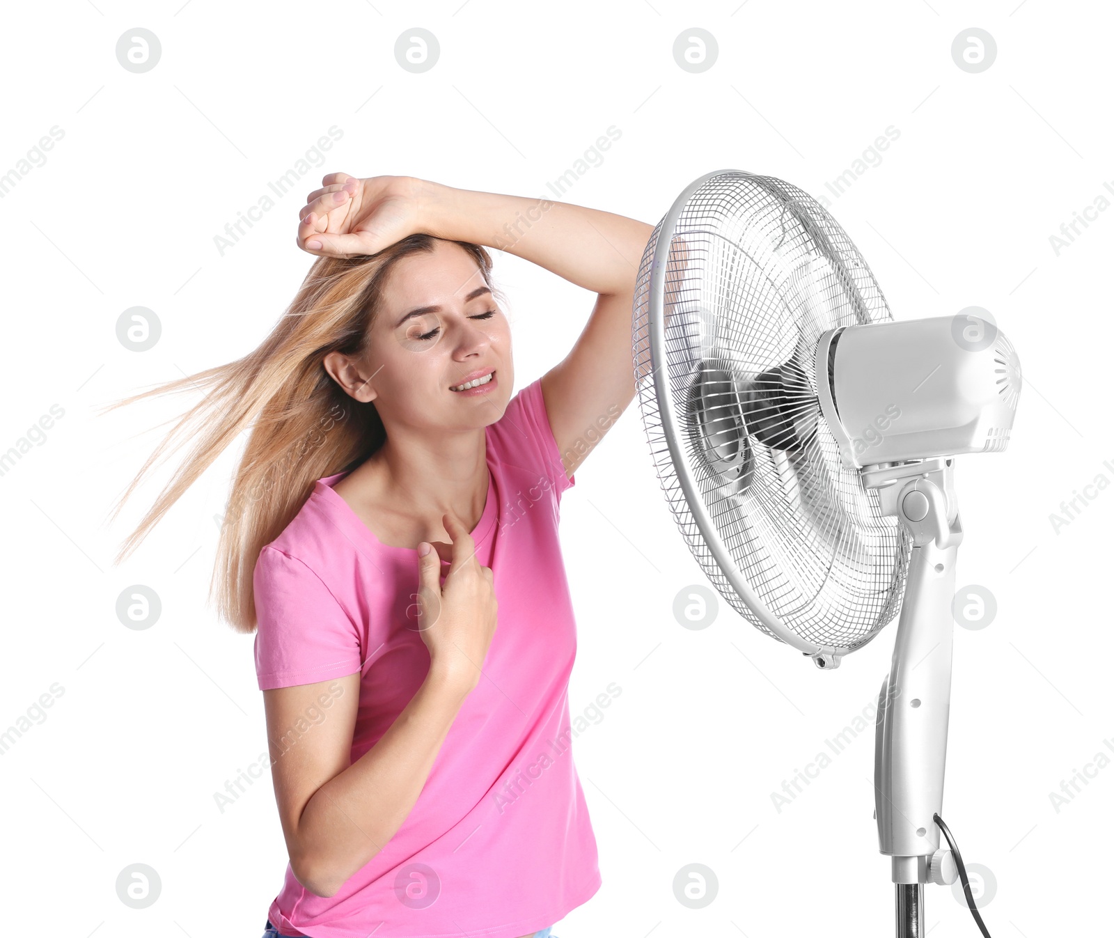 Photo of Woman refreshing from heat in front of fan on white background