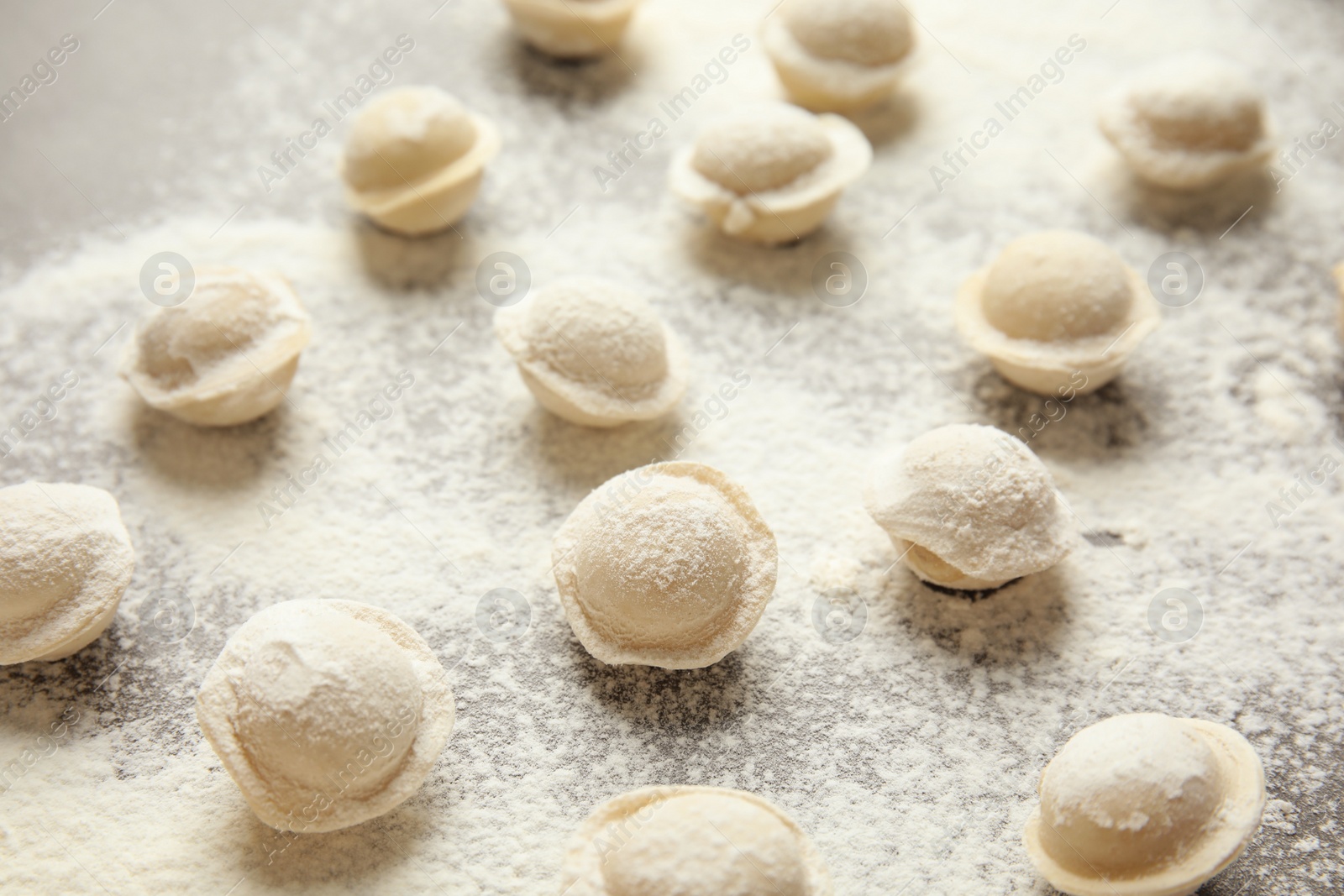 Photo of Raw dumplings on grey background, closeup. Process of cooking