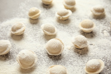 Raw dumplings on grey background, closeup. Process of cooking