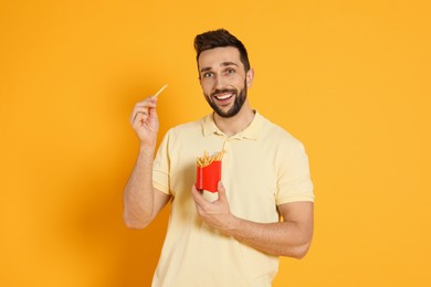 Photo of Man with French fries on yellow background