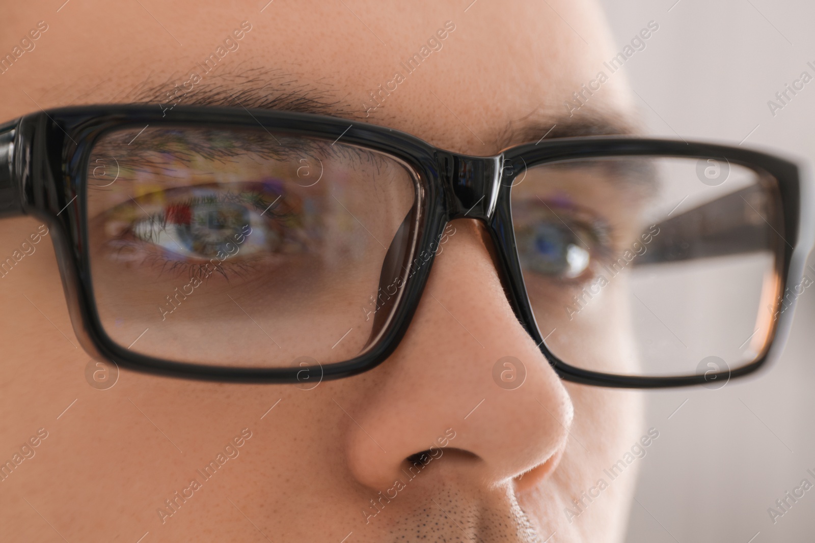 Photo of Man wearing glasses on light background, closeup