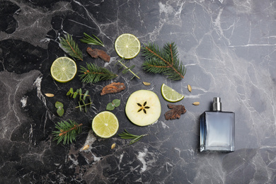 Flat lay composition with bottle of perfume on black marble background