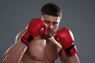 Man in boxing gloves on grey background