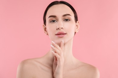 Photo of Portrait of beautiful young woman on pink background